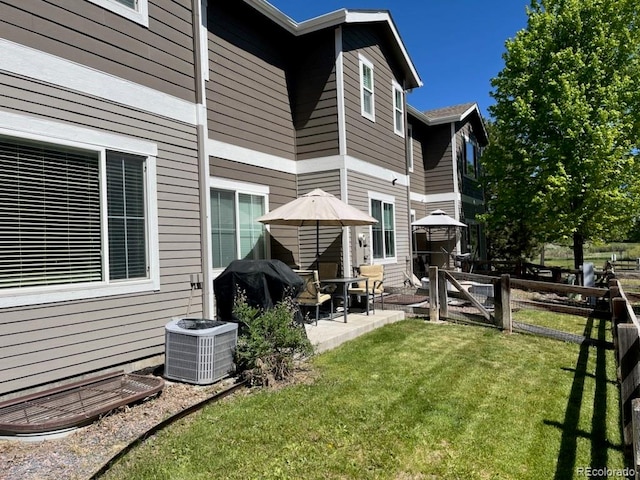 back of property featuring a patio, central AC unit, and a lawn