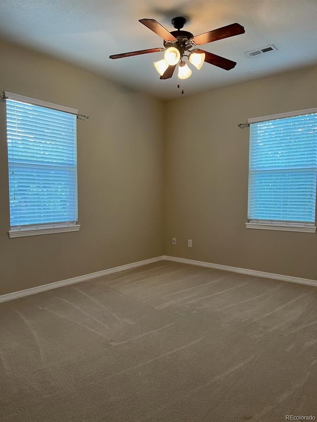 empty room featuring carpet flooring and ceiling fan