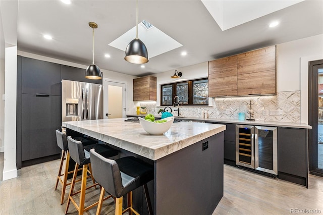 kitchen with beverage cooler, a center island, tasteful backsplash, and recessed lighting