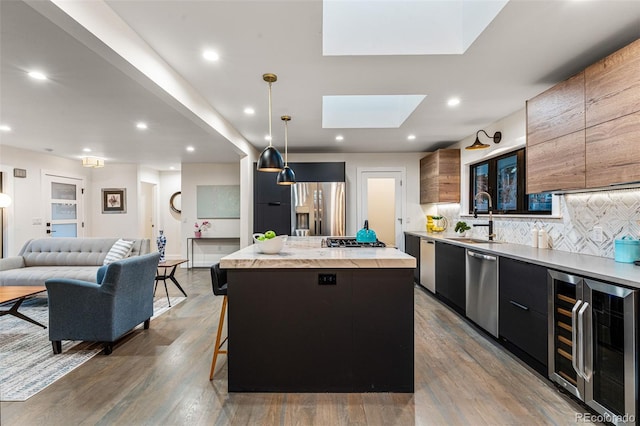 kitchen featuring beverage cooler, a kitchen island, modern cabinets, and a sink