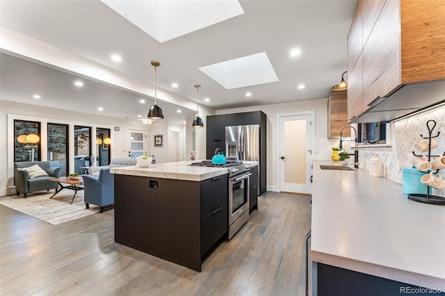 kitchen featuring a sink, a skylight, modern cabinets, and stainless steel range
