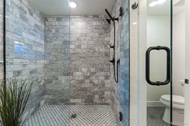 bathroom featuring a stall shower, tile patterned flooring, and toilet