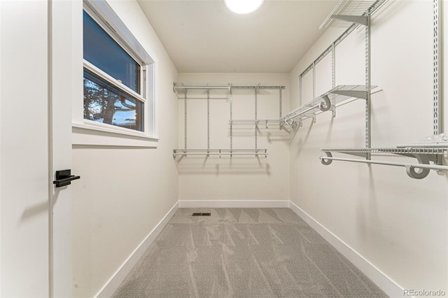 walk in closet featuring light carpet and visible vents