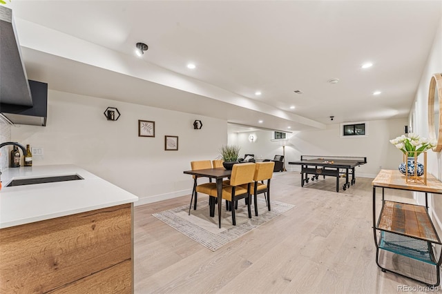 dining room featuring baseboards, light wood finished floors, and recessed lighting