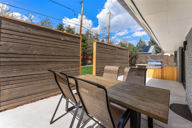 view of patio featuring area for grilling, outdoor dining space, a fenced backyard, and grilling area