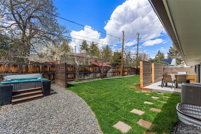 view of yard featuring a hot tub, central AC unit, a fenced backyard, and a patio