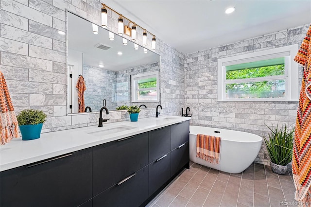 3275 19th St, Boulder, CO 80304 - bathroom featuring healthy amount of natural light, tile walls, double vanity, a freestanding tub, and tile patterned flooring