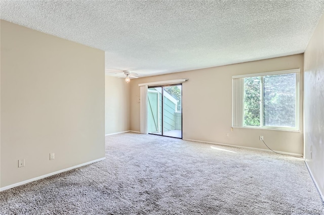 carpeted spare room featuring ceiling fan and a textured ceiling