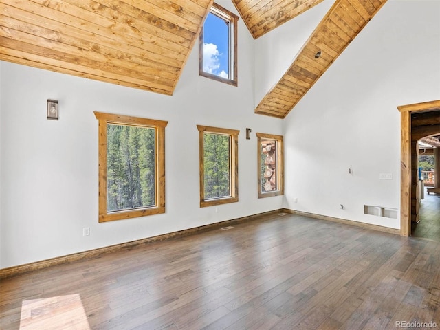 unfurnished living room featuring a healthy amount of sunlight, dark wood-type flooring, and high vaulted ceiling