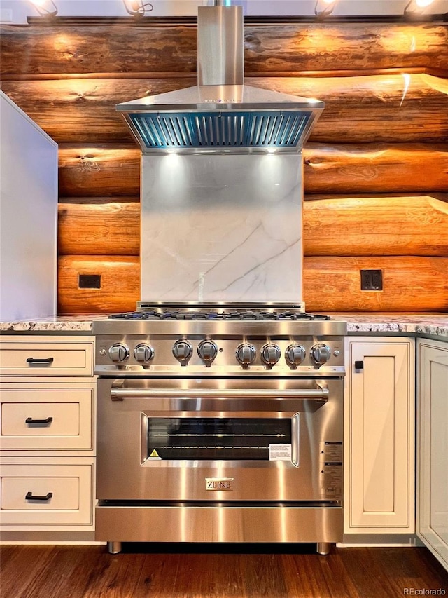 kitchen featuring dark hardwood / wood-style flooring, log walls, high end stove, and island exhaust hood