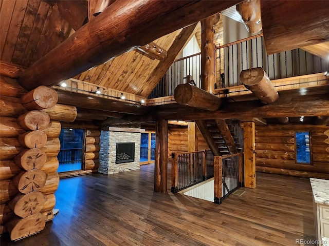 733 Rainbow Rd, Idaho Springs, CO 80452 - unfurnished living room featuring high vaulted ceiling, rustic walls, beamed ceiling, wood-type flooring, and wooden ceiling
