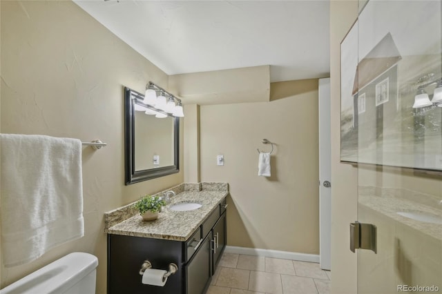 bathroom with tile patterned flooring, vanity, toilet, and baseboards