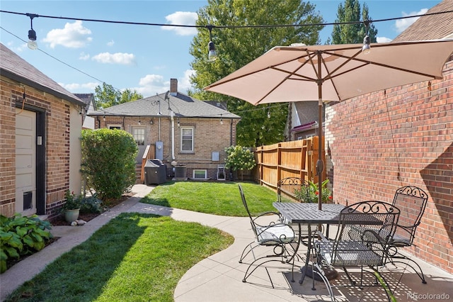 view of yard featuring outdoor dining area, a patio area, and fence