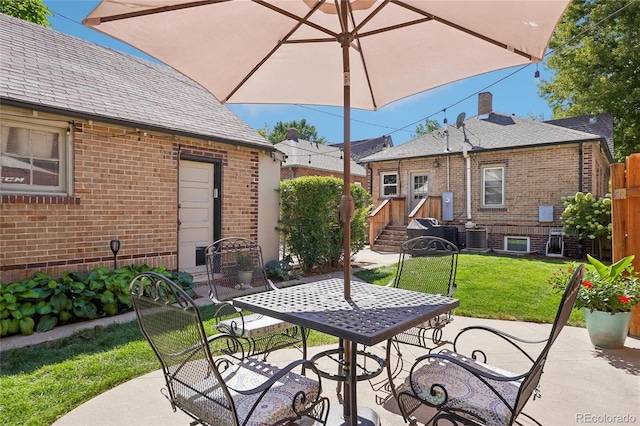 view of patio / terrace featuring outdoor dining space, central AC unit, and fence