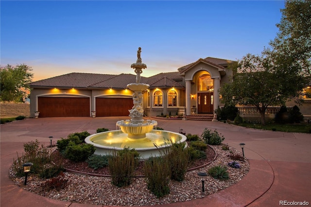 11541 Warrington Ct, Parker, CO 80138 - mediterranean / spanish house with curved driveway, a tile roof, stucco siding, and a garage