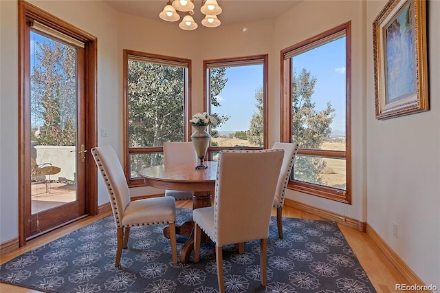 11541 Warrington Ct, Parker, CO 80138 - dining area with a chandelier, light wood-type flooring, and baseboards