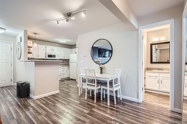 dining space featuring dark wood finished floors and baseboards