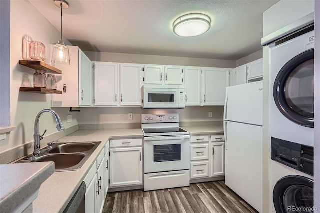 kitchen featuring stacked washer and dryer, a sink, dark wood finished floors, white appliances, and open shelves