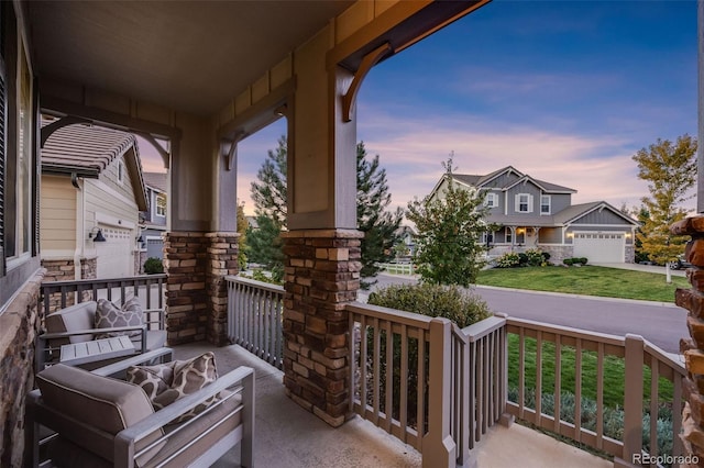 patio terrace at dusk featuring covered porch and a garage