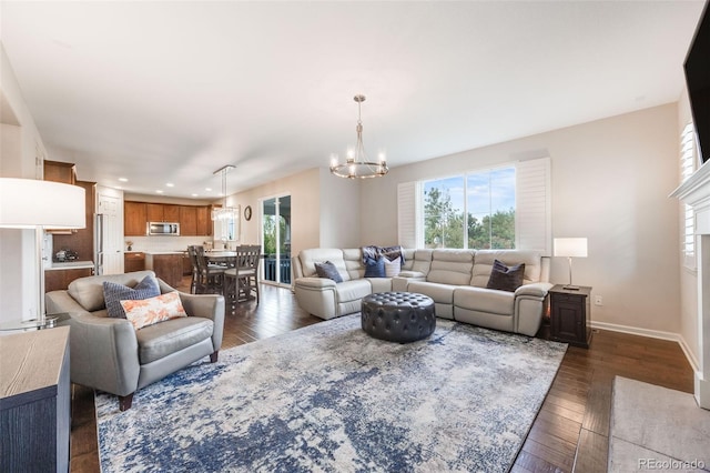 living room with a premium fireplace, a chandelier, a wealth of natural light, and dark hardwood / wood-style floors