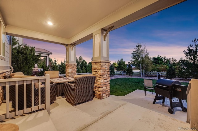 patio terrace at dusk with a fire pit and area for grilling