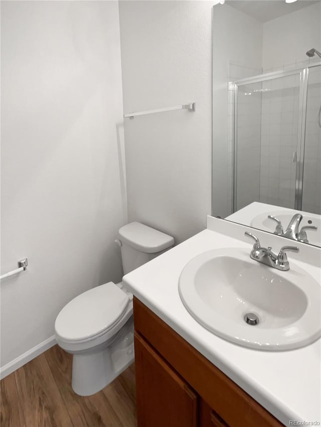 bathroom featuring vanity, walk in shower, hardwood / wood-style floors, and toilet