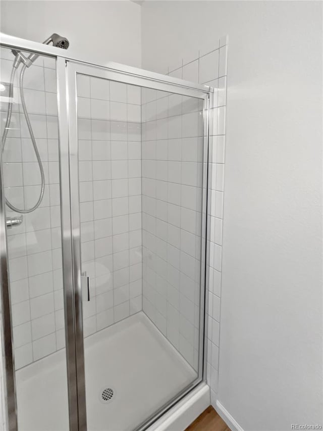 bathroom featuring wood-type flooring and an enclosed shower