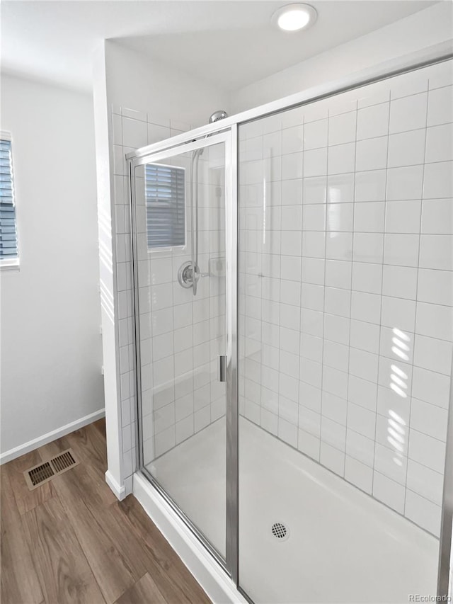 bathroom with hardwood / wood-style floors and a shower with door