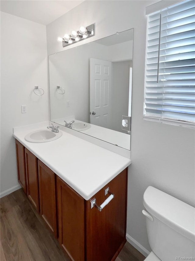 bathroom featuring hardwood / wood-style flooring, toilet, and vanity