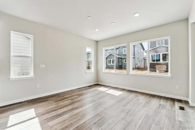 spare room with recessed lighting, visible vents, baseboards, and wood finished floors