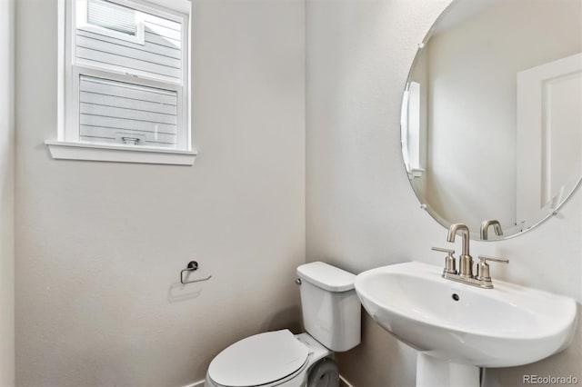 half bath featuring toilet and a sink