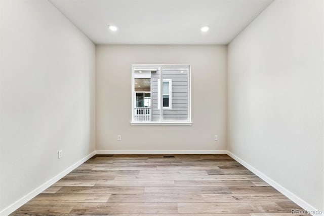 spare room with recessed lighting, baseboards, and light wood finished floors