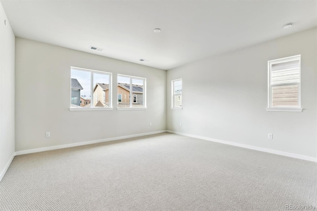 unfurnished room with visible vents, carpet floors, and baseboards