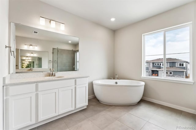 bathroom featuring a freestanding tub, visible vents, a shower stall, baseboards, and vanity