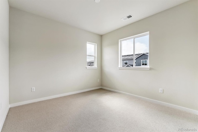 empty room with visible vents, baseboards, and carpet floors