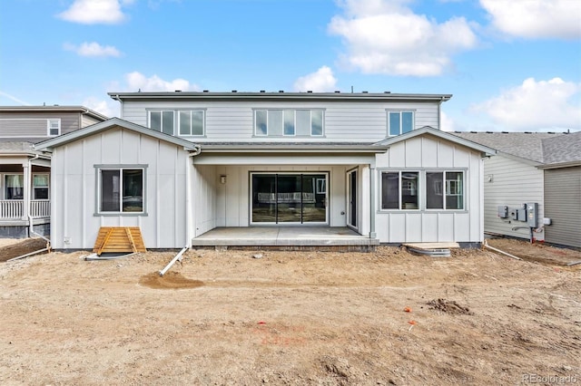 back of house with board and batten siding and a patio area