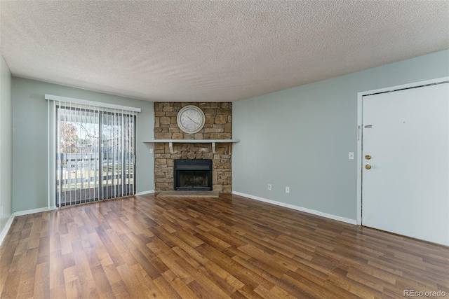 unfurnished living room with a stone fireplace, wood-type flooring, and a textured ceiling