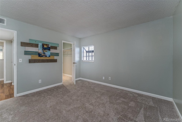 spare room featuring carpet flooring and a textured ceiling