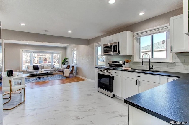 784 S 3rd Ave, Brighton, CO 80601 - kitchen with appliances with stainless steel finishes, a sink, dark countertops, plenty of natural light, and recessed lighting