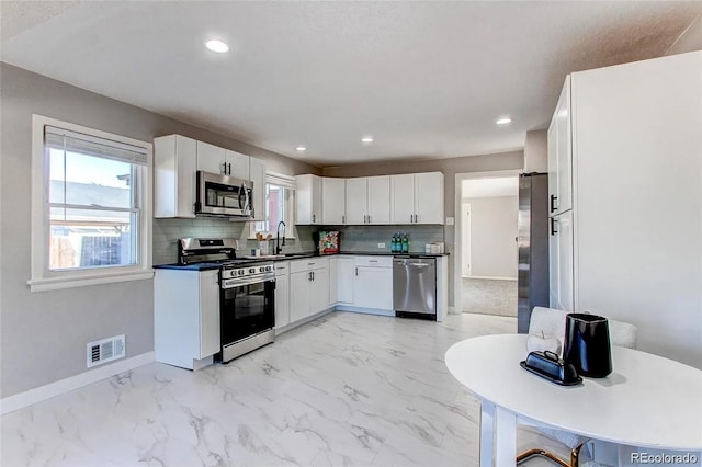 784 S 3rd Ave, Brighton, CO 80601 - kitchen with appliances with stainless steel finishes, light marble finish flooring, a sink, tasteful backsplash, and baseboards