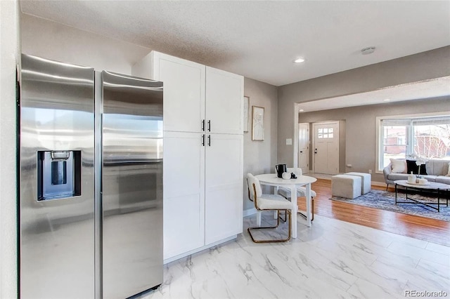 784 S 3rd Ave, Brighton, CO 80601 - kitchen featuring stainless steel fridge with ice dispenser, white cabinetry, light marble finish floors, open floor plan, and recessed lighting