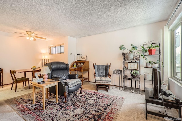 sitting room featuring ceiling fan, carpet flooring, and a textured ceiling