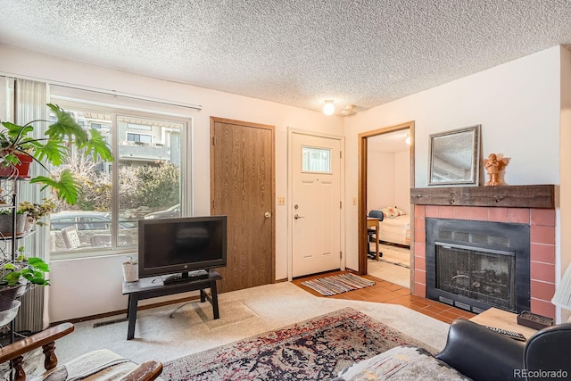 living room with a tiled fireplace and a textured ceiling