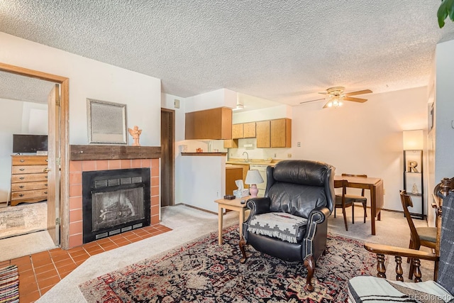 tiled living room featuring a tiled fireplace, ceiling fan, sink, and a textured ceiling