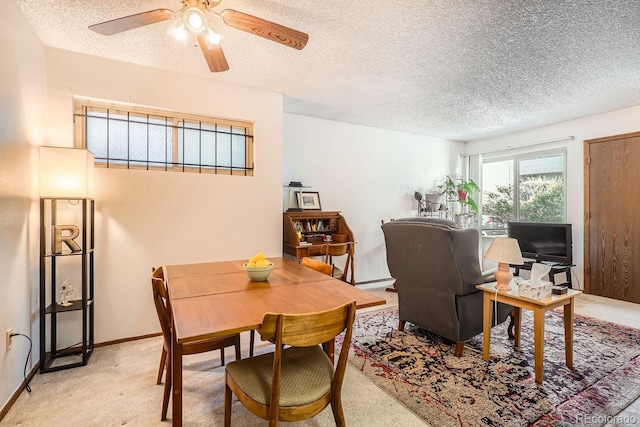 carpeted dining space with ceiling fan and a textured ceiling