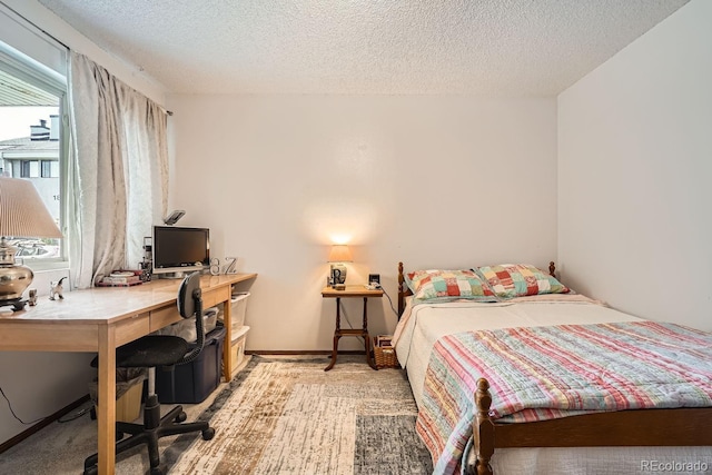 bedroom featuring light carpet and a textured ceiling