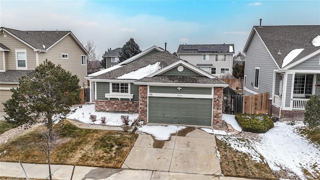 traditional-style home with concrete driveway, stone siding, an attached garage, and fence