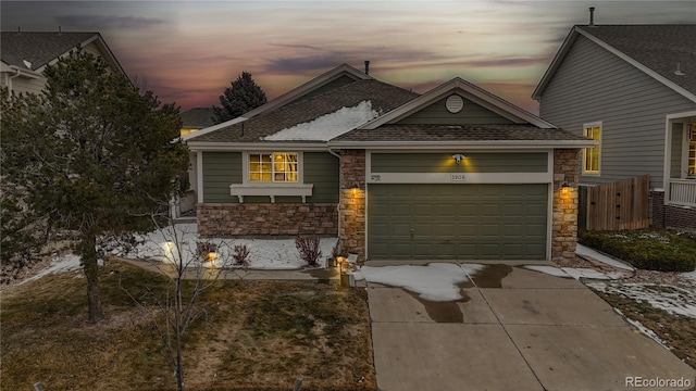 view of front of property featuring stone siding, roof with shingles, driveway, and an attached garage