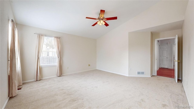 carpeted empty room featuring lofted ceiling, visible vents, ceiling fan, and baseboards