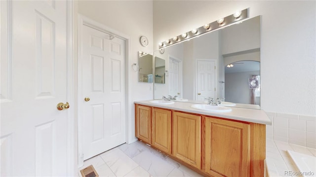 bathroom with double vanity, marble finish floor, visible vents, and a sink